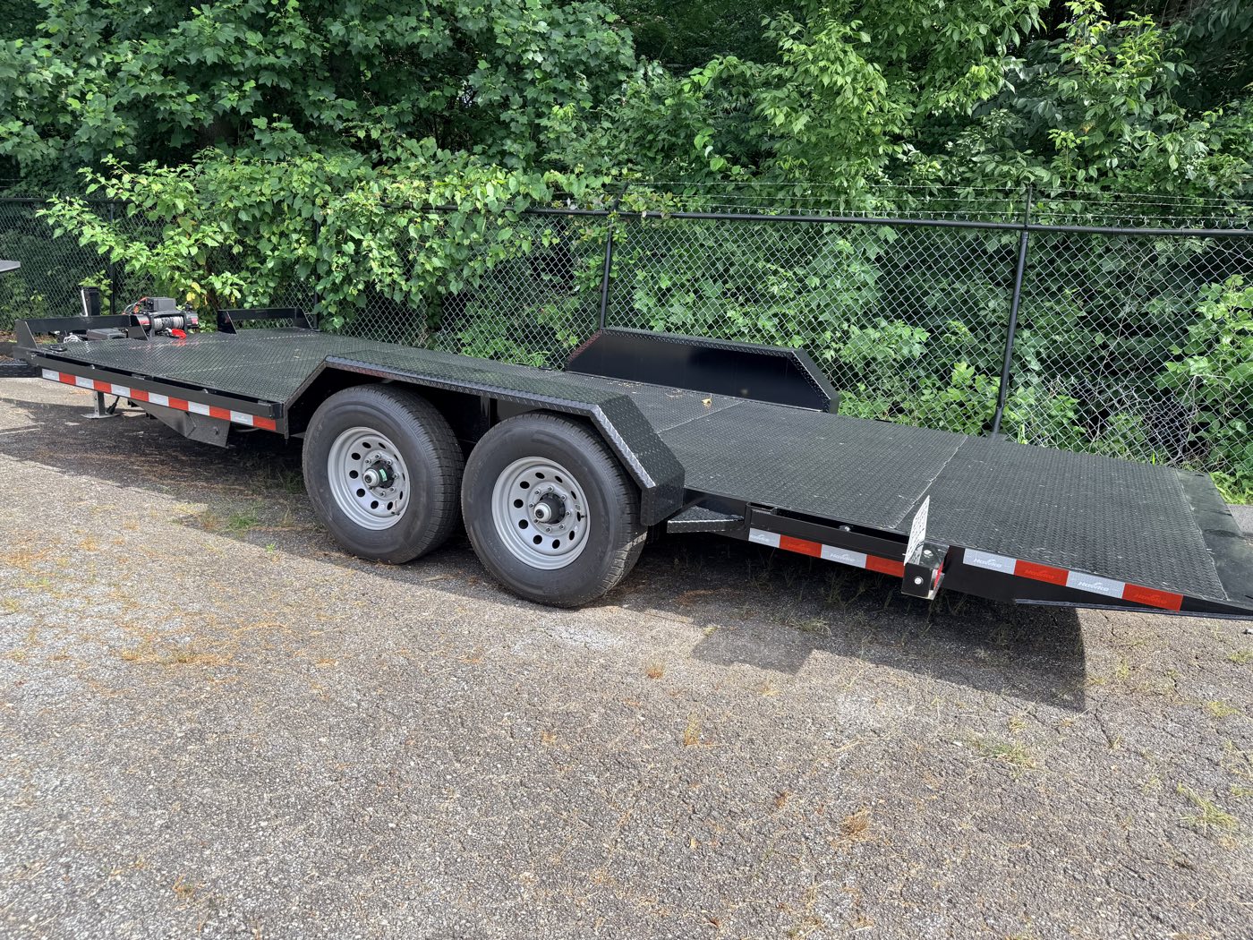 The hauler deck power-tilted down to the ground for loading